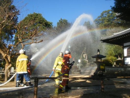 消防隊と分団が放水をしている写真