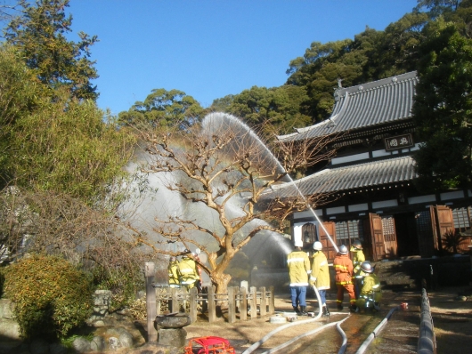 消防隊が延焼危険がある箇所に放水をしている写真