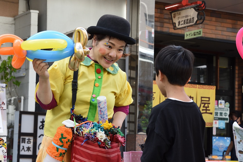 子どもにバルーンアートを披露するパフォーマー