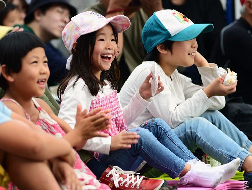 パフォーマンスを見る子どもが満面の笑みを浮かべている