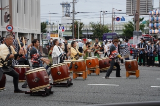 さつき通りで太鼓を勢いよく演奏する参加者たち