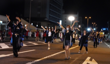 夜のさつき通りでかっぽれを踊る参加者たち