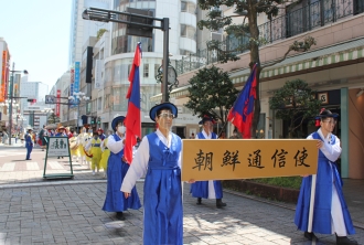 朝鮮通信使のプレートを持った人々が街中を歩いている
