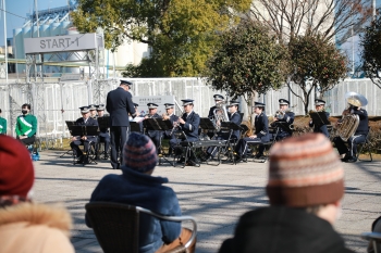 紺色の制服を着た音楽隊が奏でるメロディーに聴き入る人々。
