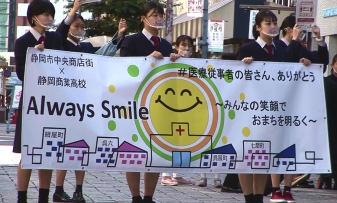 医療従事者への感謝の言葉を書いたボードを持ち行進する静岡商業高校の生徒