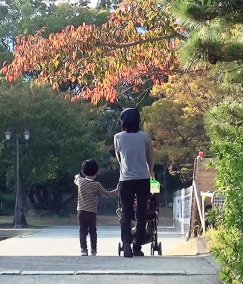 ベビーカーを押す母親の横を楽しそうに歩く子ども