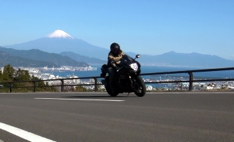 黒いバイクで日本平を走るライダーとその背には富士山