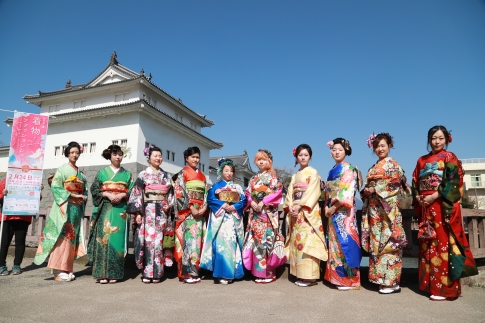 色鮮やかな着物で着飾った華やかなモデル女性たちが巽櫓を背景に集合